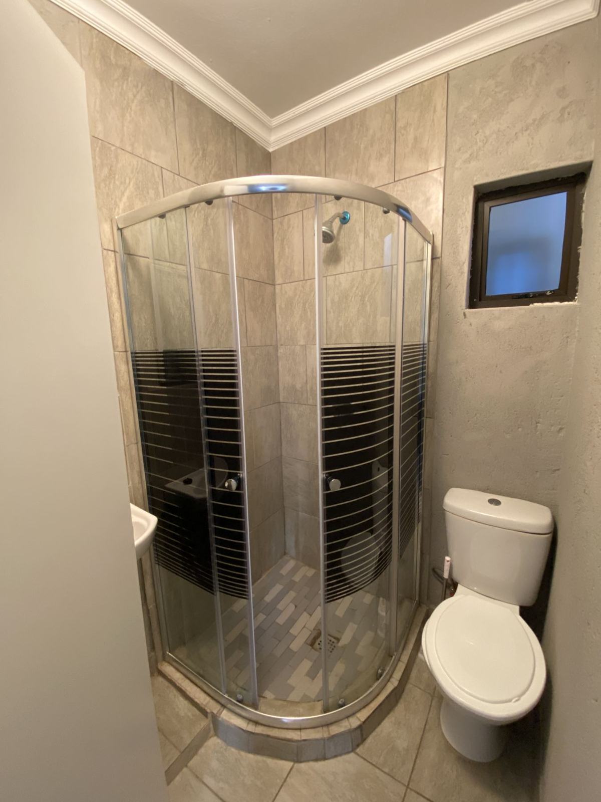 Private bathroom with glass shower and toilet